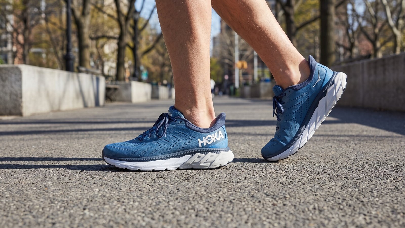 Runner wearing blue Hoka Arahi stability running shoes while striding along a paved outdoor path