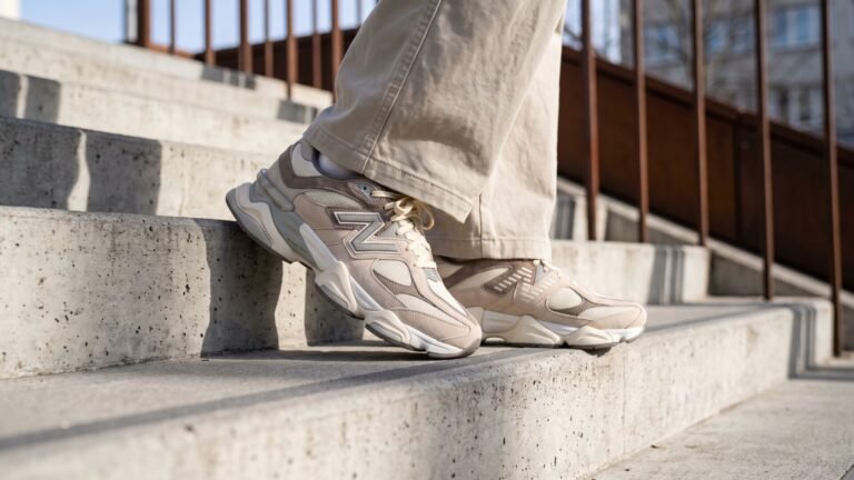 Close-up of beige New Balance 9060 sneakers worn on outdoor concrete stairs