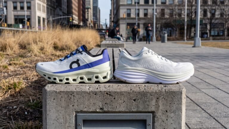 Profile view of an On Cloudmonster and Hoka Bondi 8 running shoe resting side by side on a concrete ledge