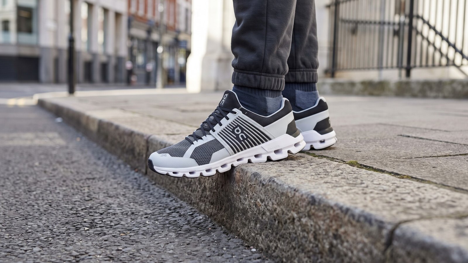 Close-up of On Cloudswift running sneakers worn on an urban sidewalk curb