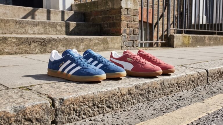 Blue Adidas Gazelle and red Puma Palermo sneakers displayed side by side on a stone pavement curb