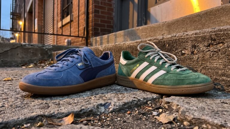 A blue suede Puma Palermo and a green Adidas Handball Spezial resting side by side on concrete steps