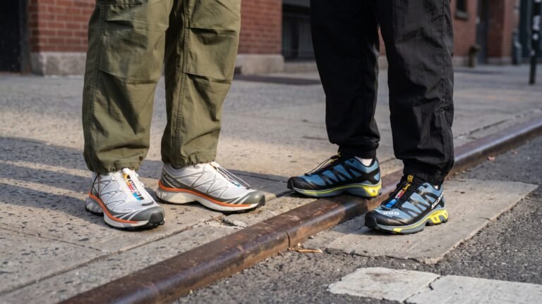 Low-angle view of two people wearing Salomon XT-6 and XT-4 sneakers on a city sidewalk